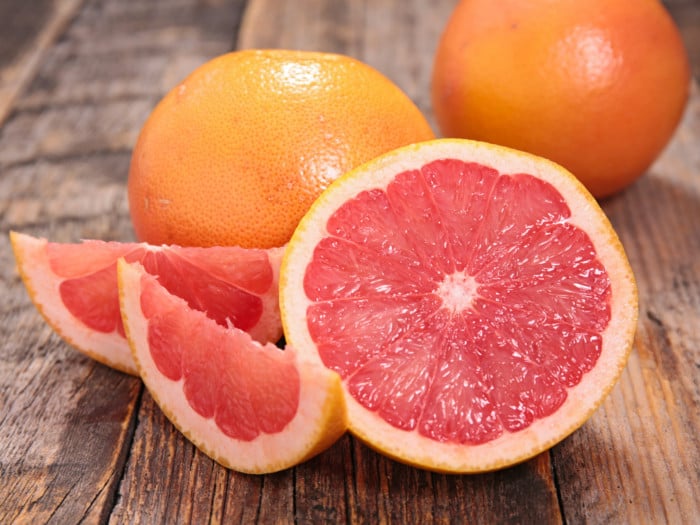 A closeup view of whole and sliced grapefruit