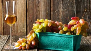A glass of wine alongside a bunch of grapes