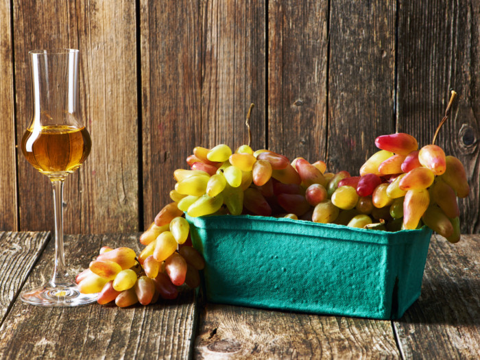 A glass of wine alongside a bunch of grapes