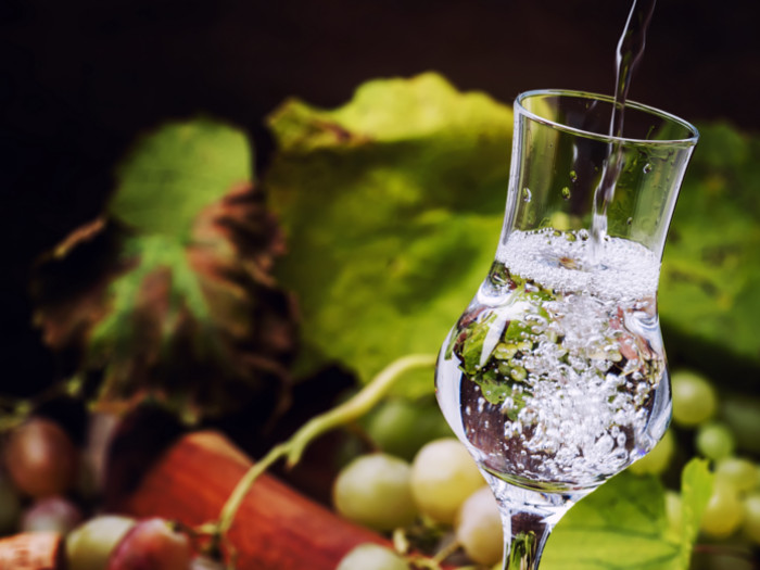 Close up of grappa with grapes in the background