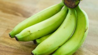 Close up of fresh green bananas on a wooden table