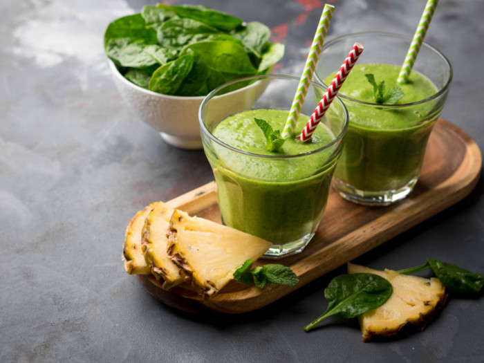 Green smoothie on a tray with pineapples