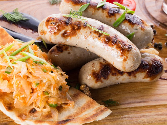 Grilled meat sausages with a side of bread and coleslaw