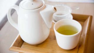 A wooden tray with a teapot and a cup containing gyokuro tea