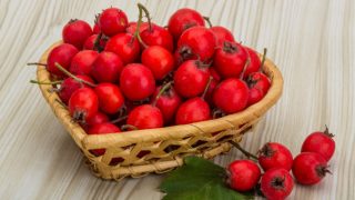 Couple of hawthorns in a basket on a wooden table