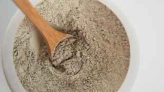 Top view of a bowl of healing clay on a white background