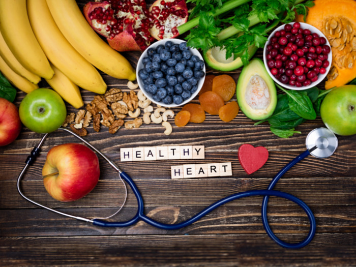 A table full of fruits and a stethoscope with words 'healthy heart' written between them
