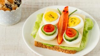 Vegetables arranged in the form of a butterfly on an open sandwich