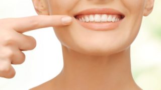 A woman smiling and showing her teeth into the camera