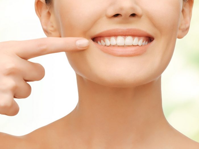 A woman smiling and showing her teeth into the camera