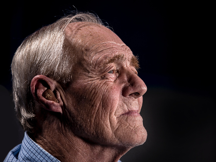 Older adult male with a hearing aid fitted