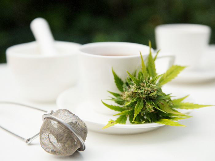 Cannabis in a cup of tea and tea strainer