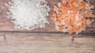 Himalayan pink salt crystals kept next to sea salt crystals