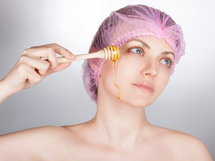 A woman applying honey to her skin