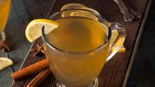 Hot toddy in a glass with spices and lemon