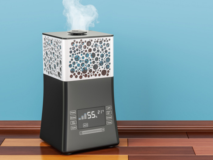 A humidifier against a blue background on a wooden floor