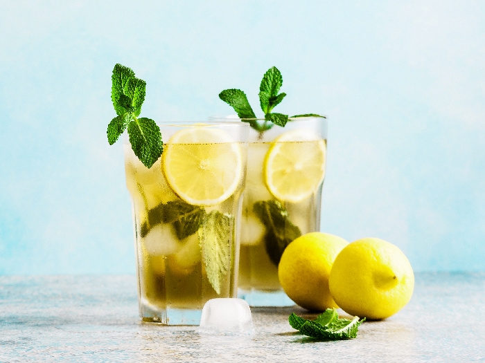 Iced green tea with lemon and fresh mint, with whole lemons