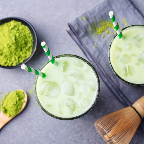 Matcha green tea ice latte with matcha powder and bamboo whisk
