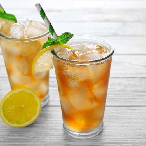 Two cocktail glasses filled with iced tea and garnished with mint leaves