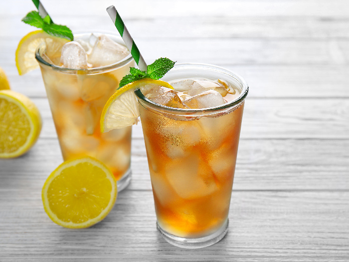 Two cocktail glasses filled with iced tea and garnished with mint leaves