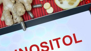 Inositol containing tablets, ginger and lime kept atop a red platform