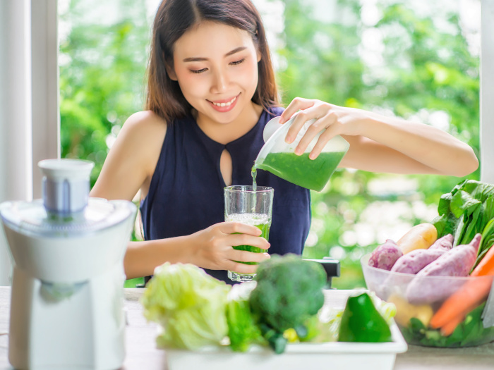 Young Asian Woman Happy Drinking Fresh Green Detox Vegetable Juice