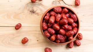 A bowl of dried jujube on a wooden table