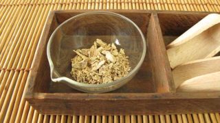 A bowl of kava tea kept in a wooden tray atop a cane platform
