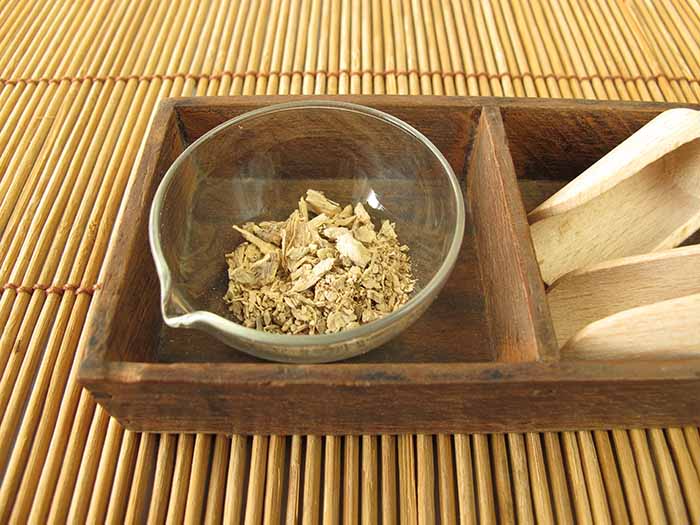 A bowl of kava tea kept in a wooden tray atop a cane platform