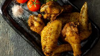 Fried chicken wings served with tomato and fine Himalayan salt garnish with parsley