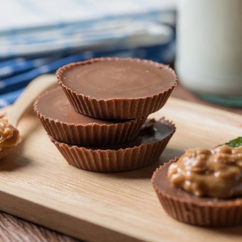 Homemade peanut butter cup, dark chocolate with caramel and bottle of milk.