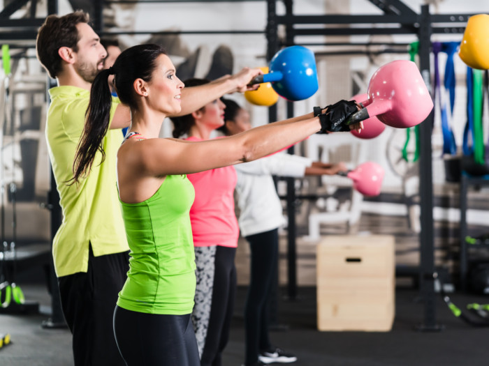 A group of people doing the kettlebell workout in a gym
