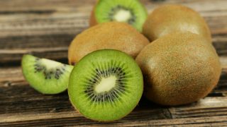A close-up view of whole and sliced kiwi fruits