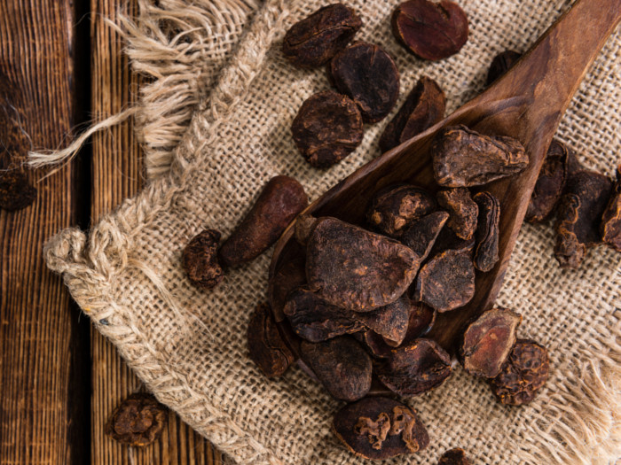 Cuchara de madera de nueces de cola secas guardadas en un paño de yute