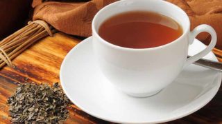 Lapsang souchong tea in a cup with tea leaves in a traditional setting