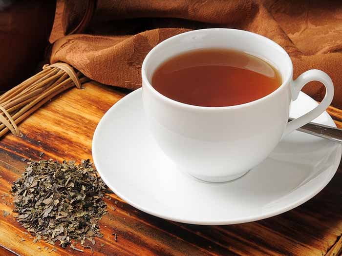 Lapsang souchong tea in a cup with tea leaves in a traditional setting