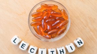A bowl of lecithin gel capsules a wooden table