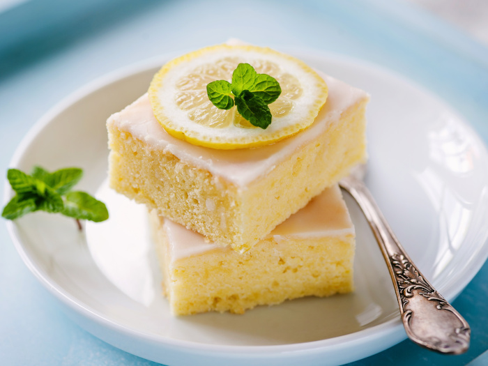 Two lemon cake pieces stacked together on a small white plate