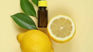 A close-up shot of lemon and lemon extract in a small bottle