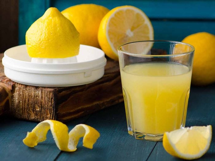 A small glass filled with lemon juice