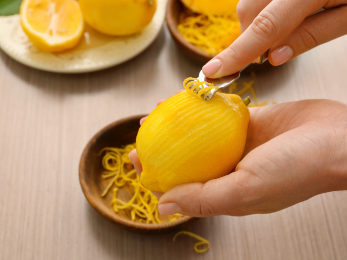 Scraping the lemon peel using a peeler