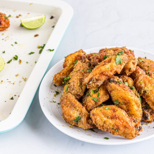 Crispy fried lemon pepper chicken wings on a white plate