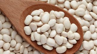 Lima beans with a wooden spoon filled with the beans