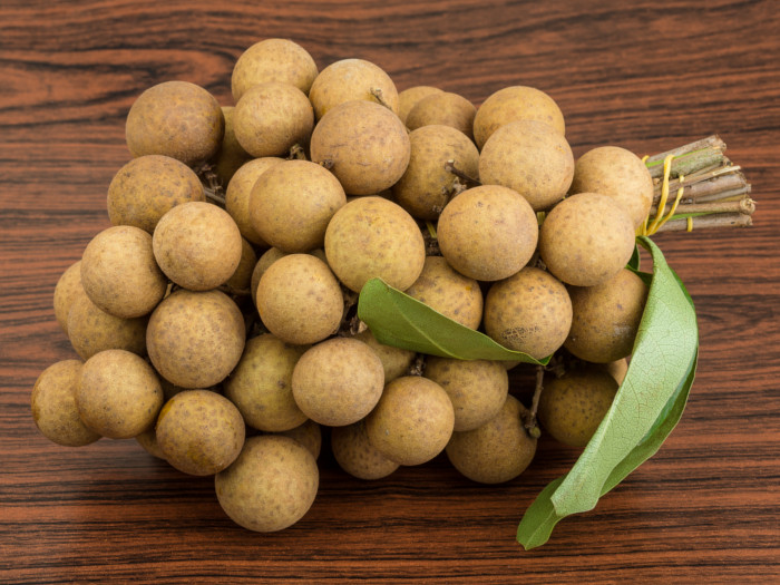 Close-up of fresh longan fruits on a wooden table