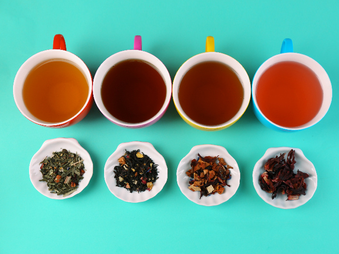 An assortment of teas in cups, with loose leaf tea
