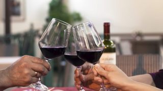 Close-up shot of clinking three wine glasses