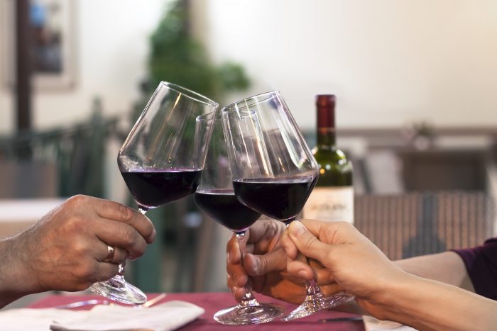 Close-up shot of clinking three wine glasses