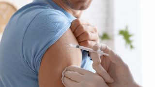 Doctor vaccinating male patient in the clinic