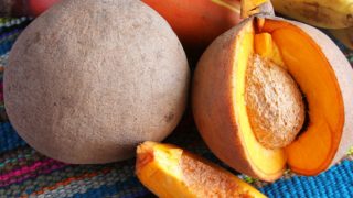 A close up shot of mamey sapote fruits, sliced and whole