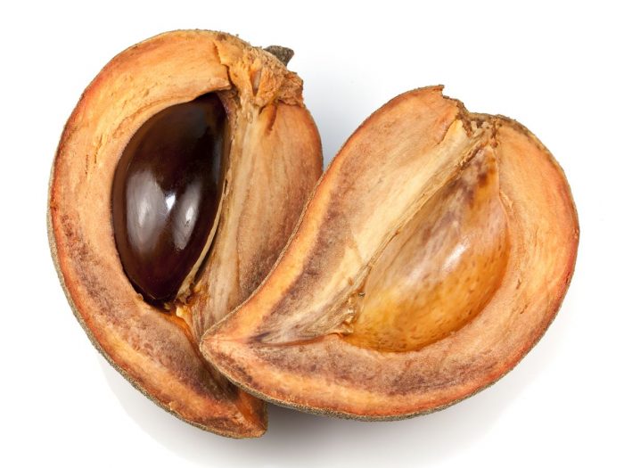 Close up of tasty halved mamey sapote fruit on a white background